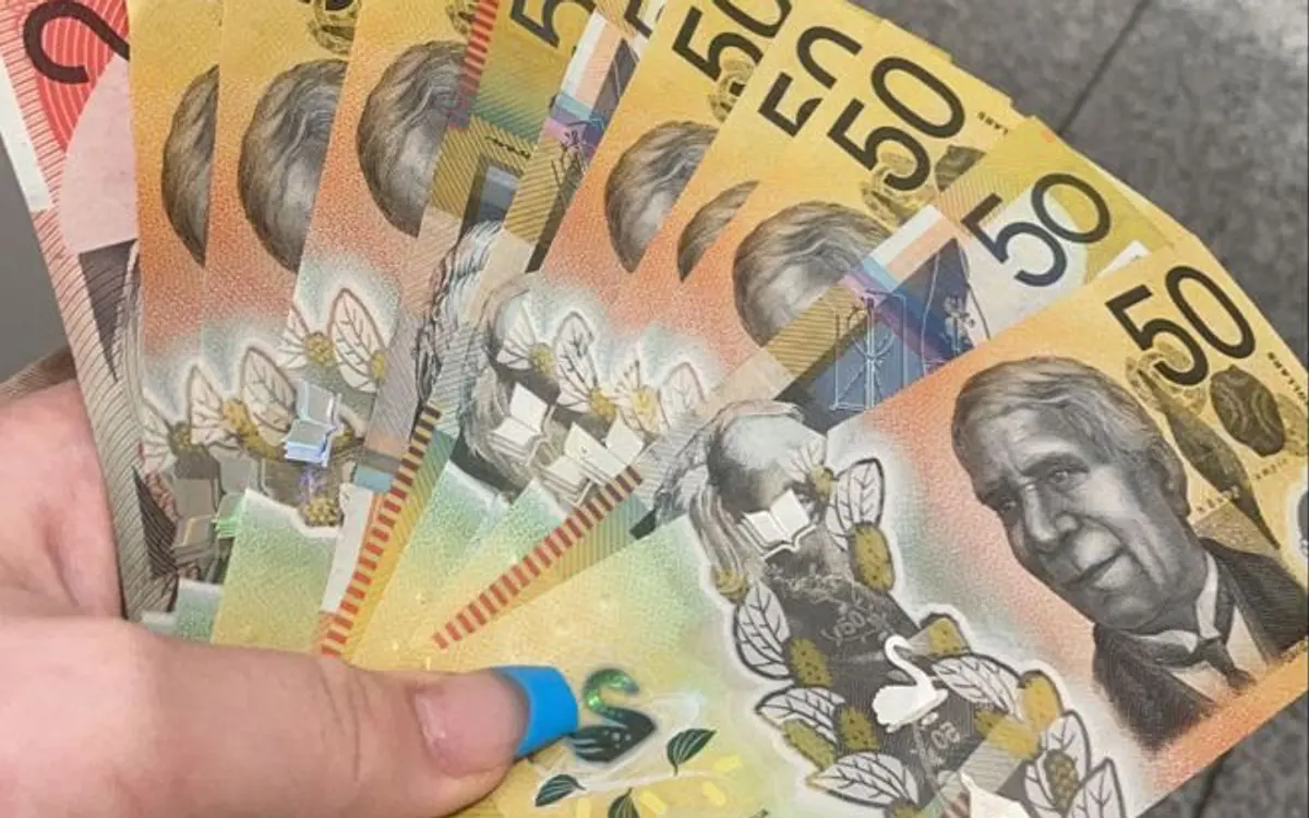 Australian play money set: specimen-marked play notes fanned in a hand for kids games