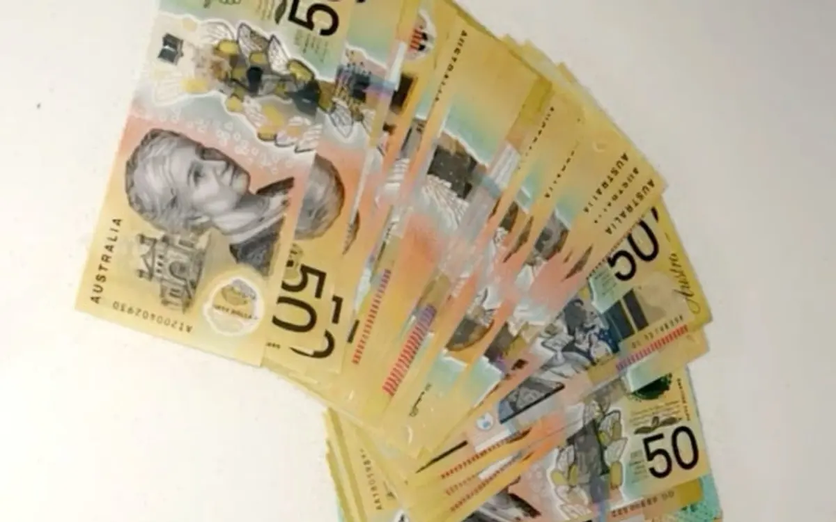 Australian polymer prop money compared with paper specimen prop notes in a hand